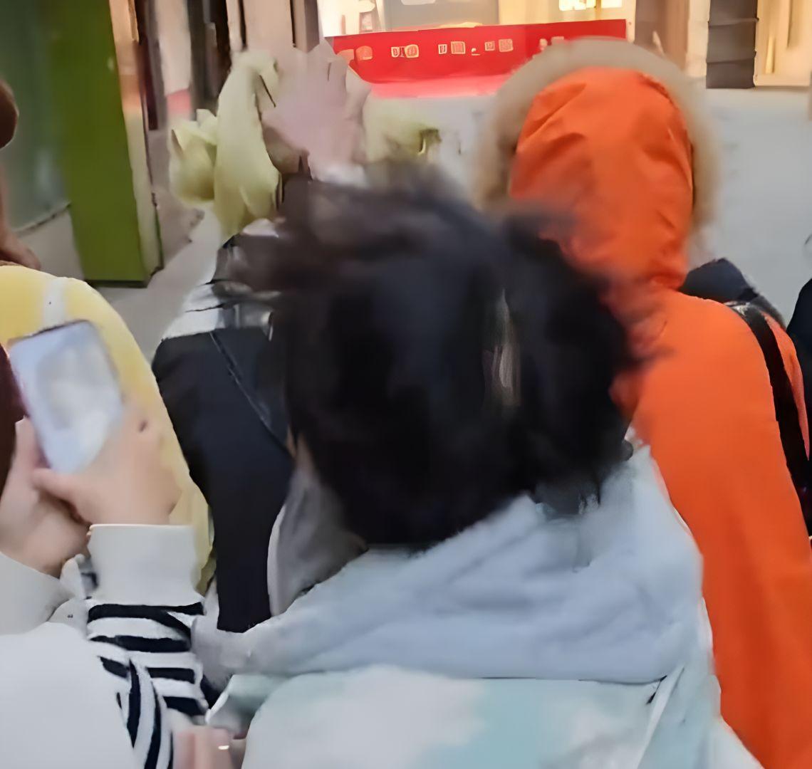 Agresseurs posant avec un drapeau chinois après avoir brûlé la perruque de la cosplayer